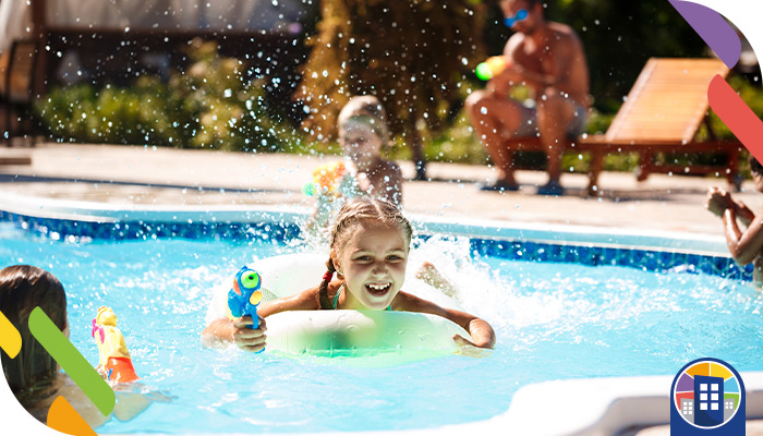 Personas disfrutando de una piscina en un condominio con medidas de seguridad y supervisión